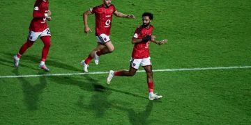 لاعبو الأهلي بقمصانهم الحمراء يحتفلون بهدف