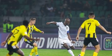 لاعب اتحاد جدة بقميصه الأبيض أمام لاعبي نيفتشي
