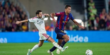 صراع على الكرة بين لاعب من برشلونة وآخر من ريال مدريد في الكلاسيكو