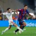 صراع على الكرة بين لاعب من برشلونة وآخر من ريال مدريد في الكلاسيكو